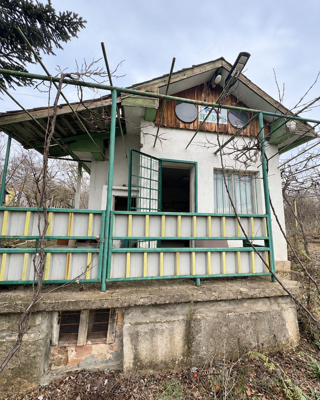 Small villa with green veranda and exterior stairs