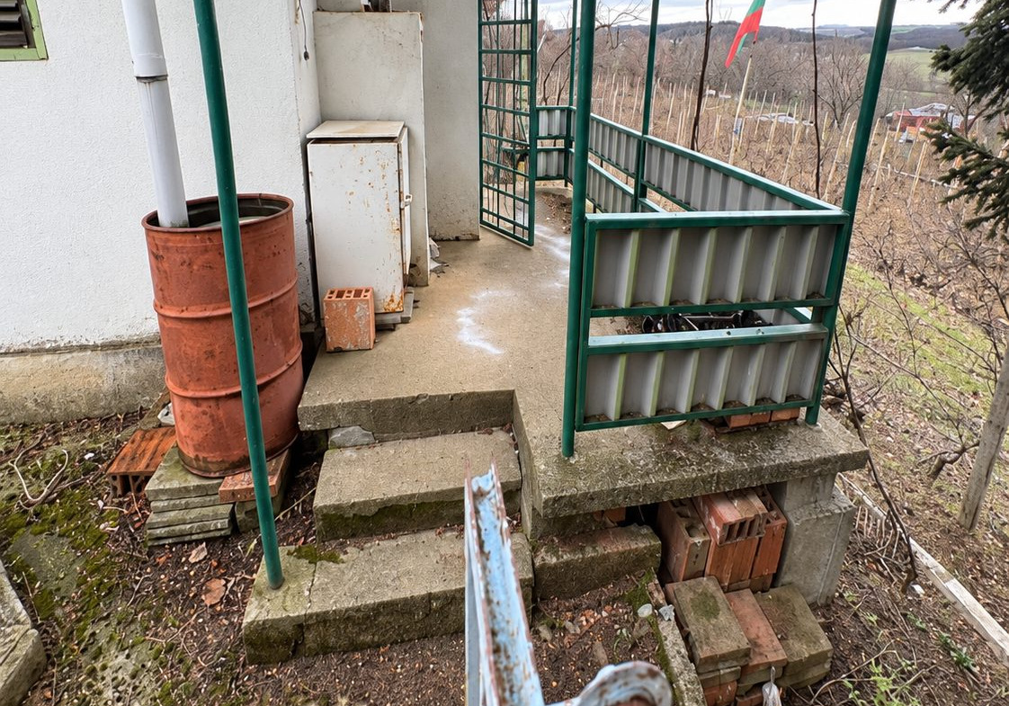 Metal gate and concrete platform overlooking countryside