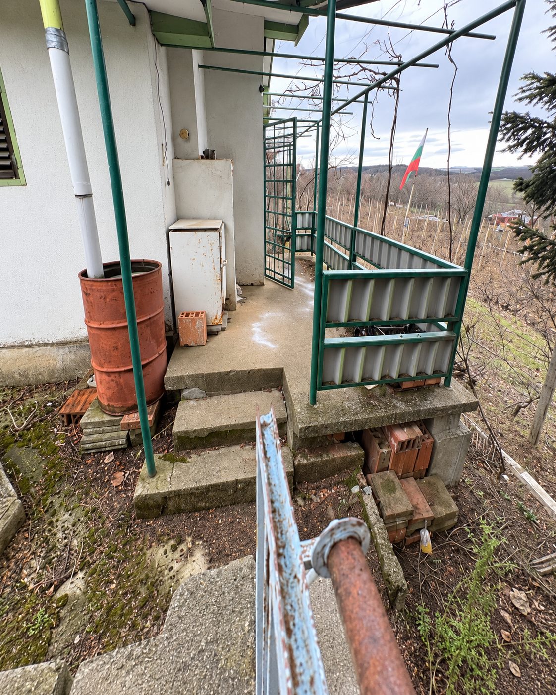 Metal gate and concrete platform overlooking countryside