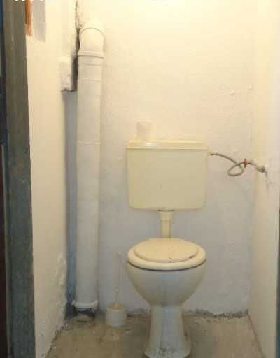 apartament-60-kvm-pod-naem-varna-bazar-levski-avtomobilen-vhod-11 Тясна тоалетна с бяла тоалетна чиния и открита тръба