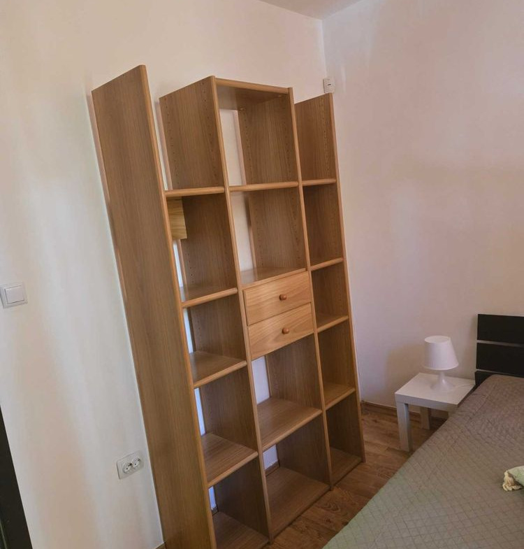 dvustaen-apartament-52-kvm-pod-naem-mladost-2-otdelen-vhod-12 Спалня с висок дървен стелаж с отворени рафтове и малко нощно шкафче