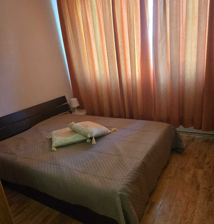 dvustaen-apartament-52-kvm-pod-naem-mladost-2-otdelen-vhod-13 Спалня с двойно легло, тъмно табло и оранжеви завеси на прозореца