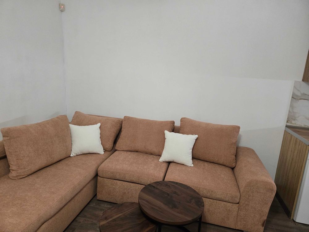 dvustaen-apartament-52-kvm-pod-naem-mladost-2-otdelen-vhod-2 Кафяв ъглов диван с бели възглавници и кръгла масичка