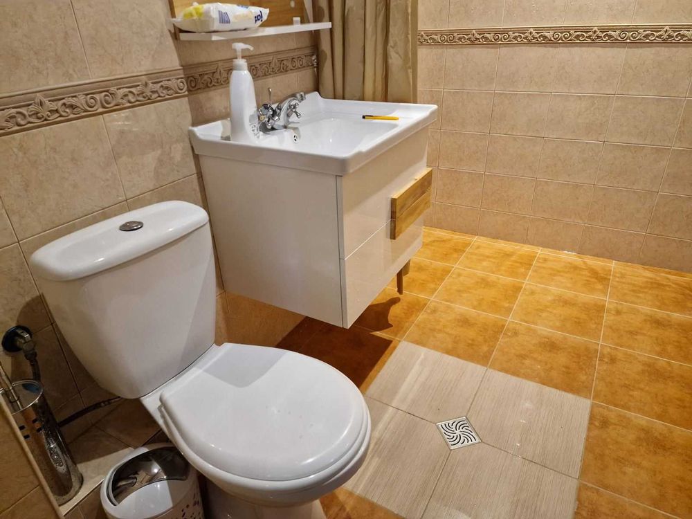 dvustaen-apartament-52-kvm-pod-naem-mladost-2-otdelen-vhod-7 Баня с тоалетна чиния, конзолна мивка и бежови плочки по стените