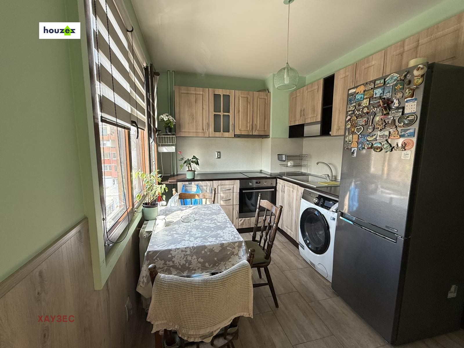 Kitchen with wood cabinets, black countertop, dining table, washing machine, refrigerator
