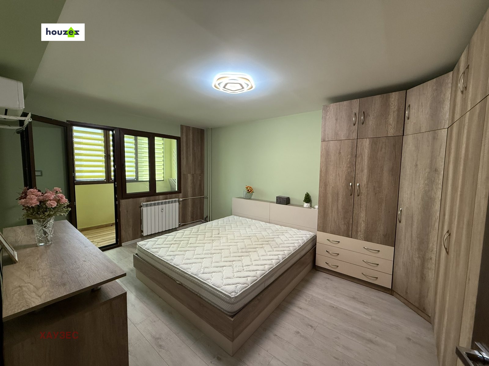 Bedroom with double bed, large wardrobe, laminate floor, air conditioner, balcony door