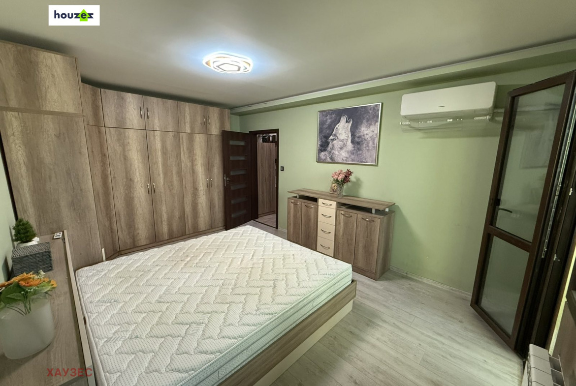 Bedroom with large wood wardrobe, double bed, dresser, wolf artwork, air conditioner