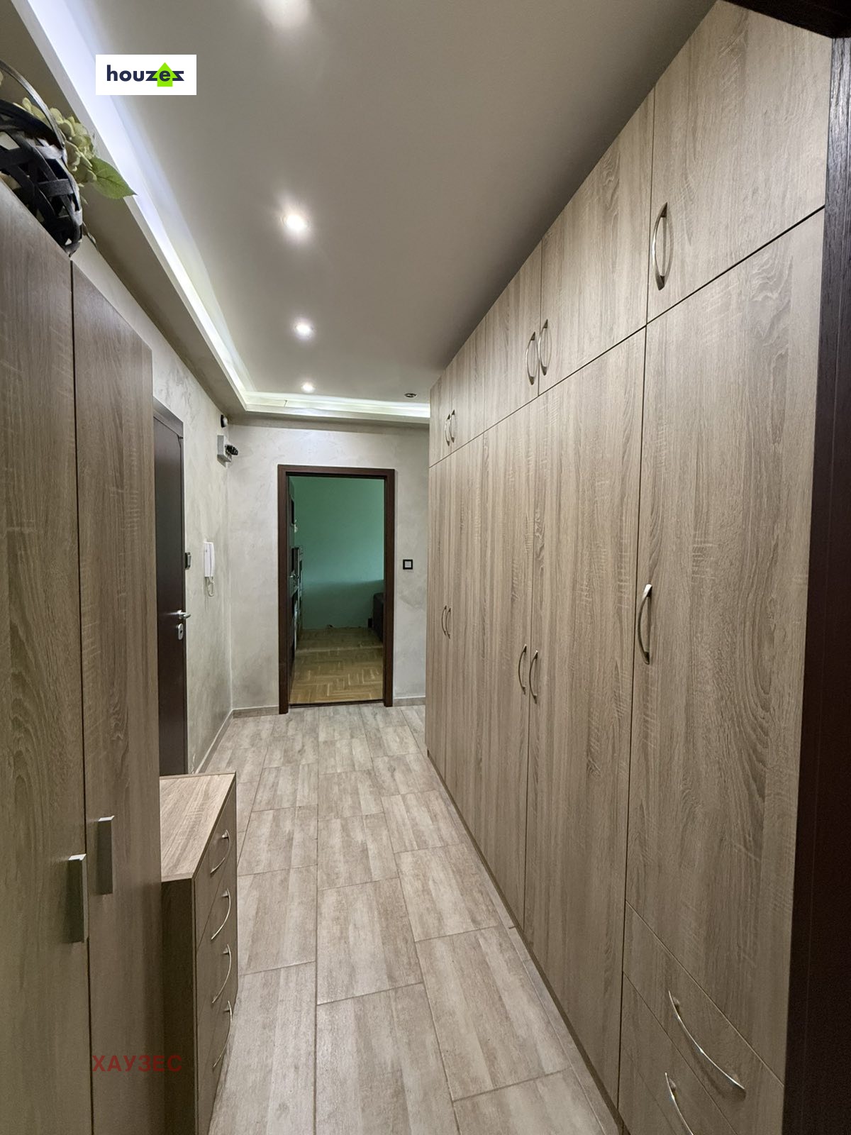 Hallway with full-length built-in wood wardrobes, recessed ceiling lights, tiled floor