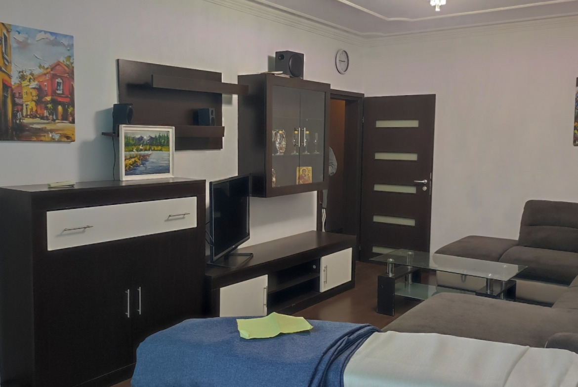 One-Bedroom Apartment in Sofia, living room with dark wall unit, TV, sofa, chandelier
