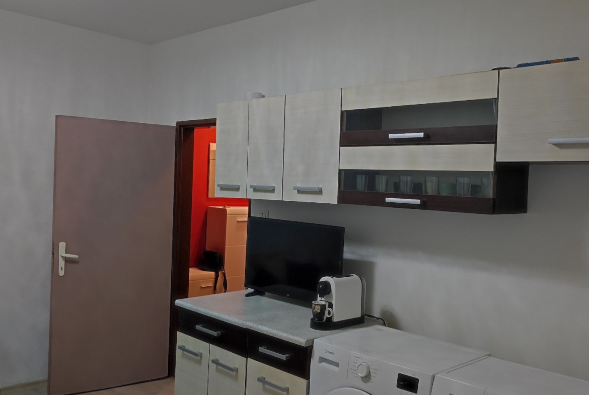 Kitchen with wall cabinets, small TV, washing machine, and dryer