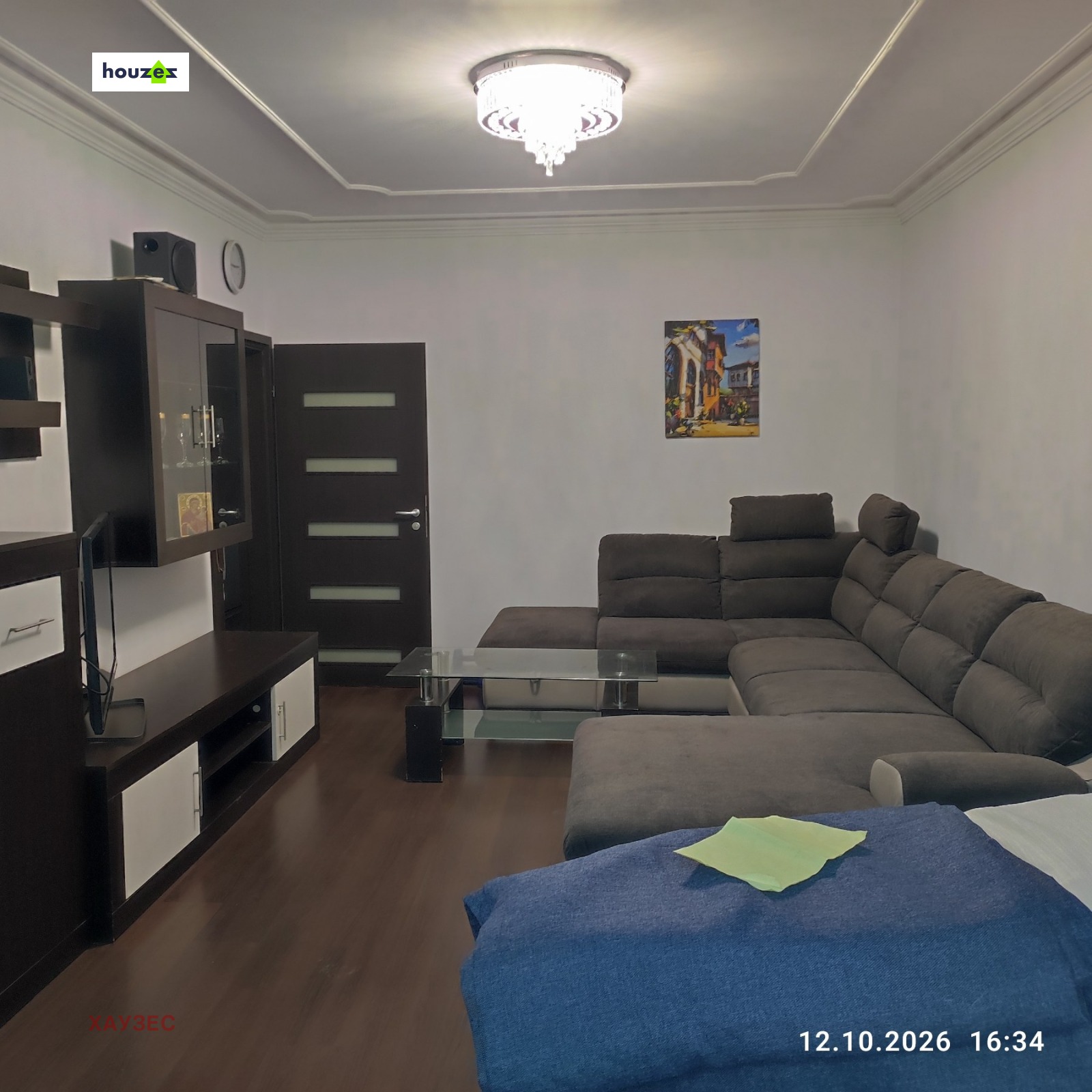 Living room with large corner sofa, glass coffee table, and TV unit