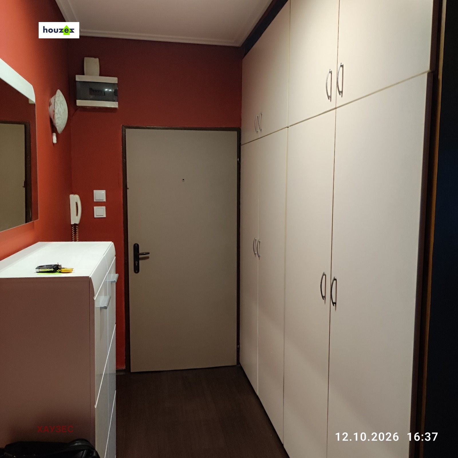 Hallway with tall white built-in wardrobe and red accent wall