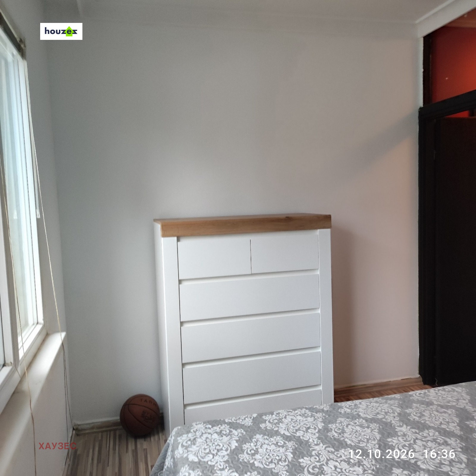 Bedroom corner with white chest of drawers and wooden top surface