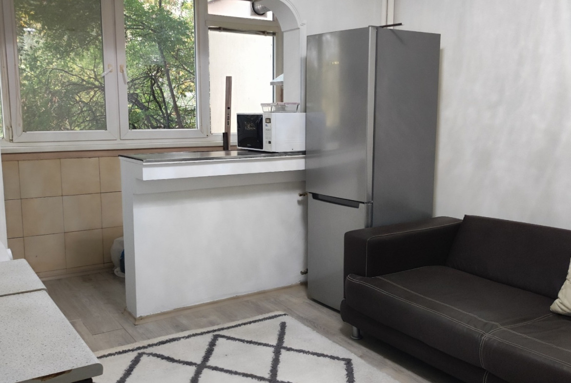 Kitchen area with stainless steel fridge, small sofa, and garden view