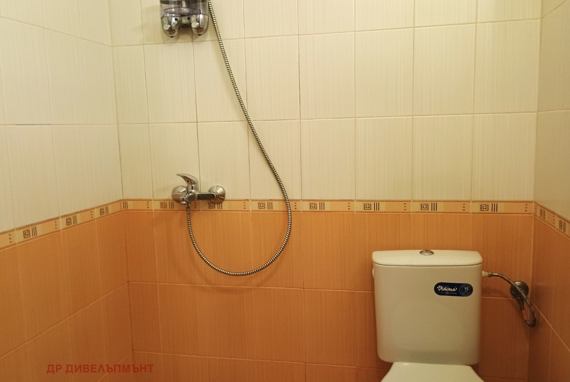 dvustaen-apartament-68-sqm-pod-naem-darvenitsa-sofiya-blizo-do-metro-10 Ъгъл на банята с тоалетна и стенен смесител с гъвкав маркуч, оранжеви плочки