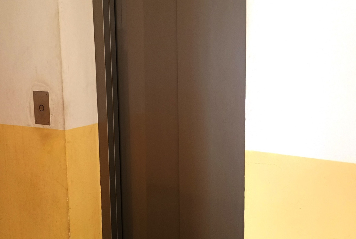 dvustaen-apartament-68-sqm-pod-naem-darvenitsa-sofiya-blizo-do-metro-16 Асансьор в сградата на пети етаж, сиви метални плъзгащи врати, жълто боядисани стени на стълбището