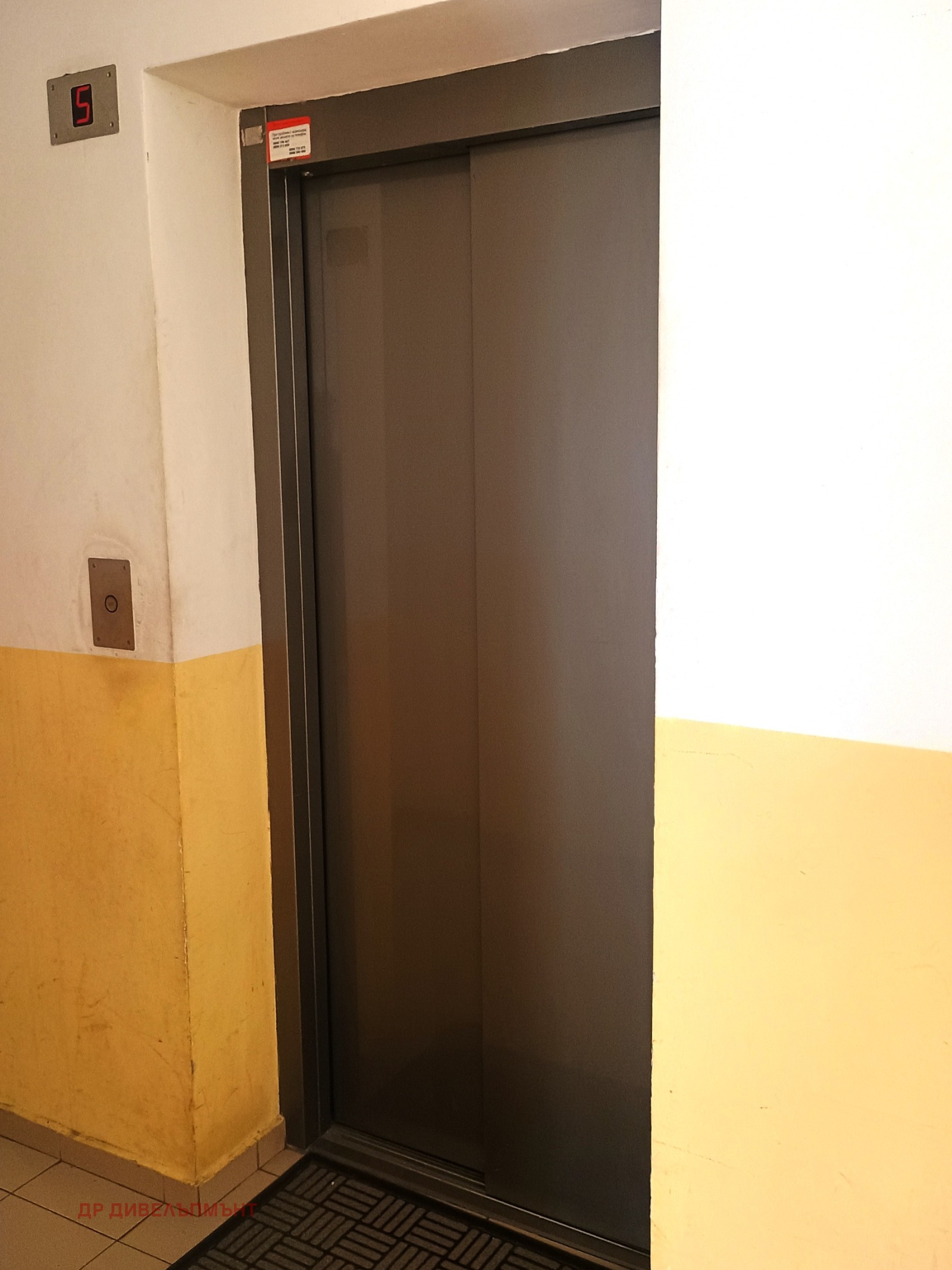 dvustaen-apartament-68-sqm-pod-naem-darvenitsa-sofiya-blizo-do-metro-16 Асансьор в сградата на пети етаж, сиви метални плъзгащи врати, жълто боядисани стени на стълбището