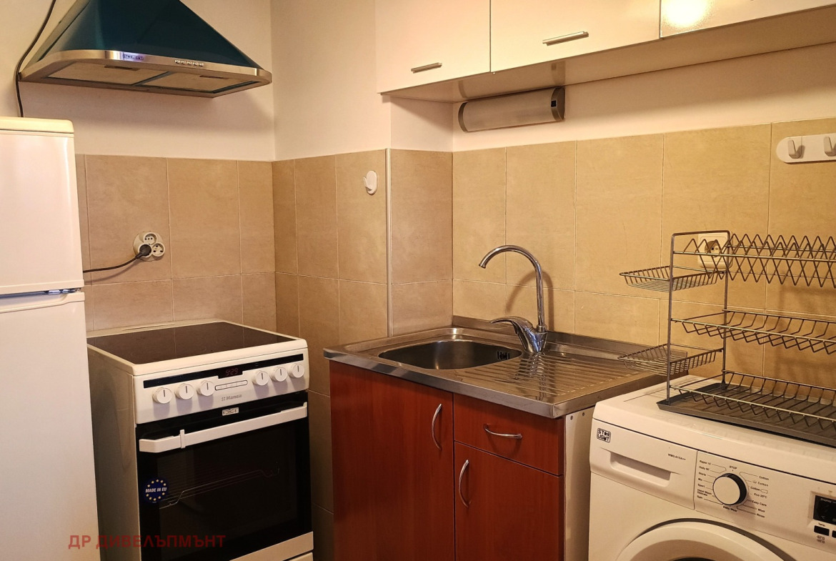 dvustaen-apartament-68-sqm-pod-naem-darvenitsa-sofiya-blizo-do-metro-8 Кухня с мивка от неръждаема стомана, електрическа печка, перална машина и стенни шкафове