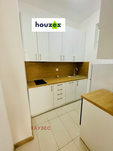 White kitchen with wall cabinets, wooden countertop, induction hob and sink