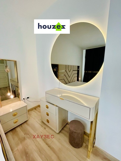 Vanity dressing table with round backlit mirror and small stool, light floor
