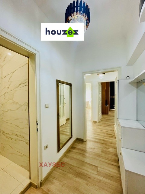 Hallway with marble-effect door, full-length mirror, white built-in storage, chandelier
