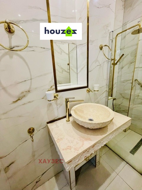 Bathroom vanity with stone vessel sink, marble countertop, gold tap and mirror