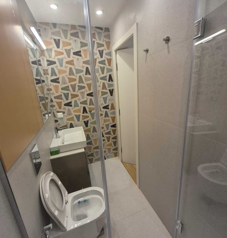 dvustaen-apartament-73-sqm-pod-naem-manastirski-livadi-sgrada-diada-11 Баня, видяна през огледало с душ кабина, окачена тоалетна, малка мивка тип купа