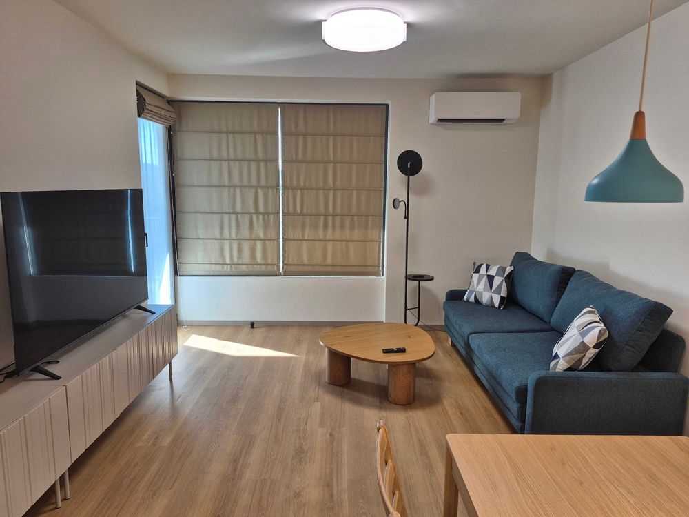 dvustaen-apartament-73-sqm-pod-naem-manastirski-livadi-sgrada-diada-3 Всекидневна със синьо диване, дървена масичка и голям телевизор