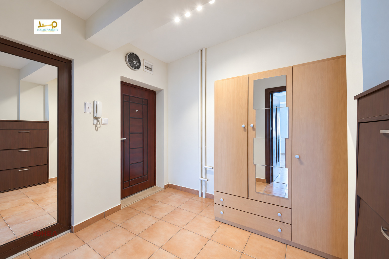 Entrance hall with front door, light wooden wardrobe with mirrors and intercom