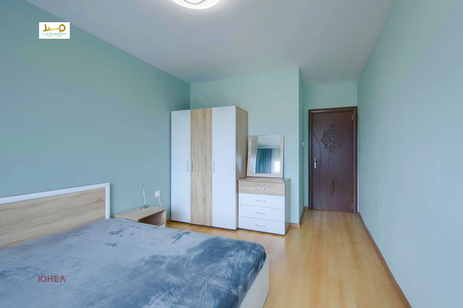 Bedroom with double bed, two-tone wardrobe, chest of drawers and mirror on stand