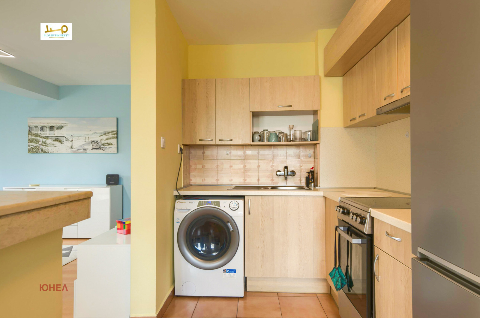 Kitchen interior with washing machine, sink, wooden wall cabinets and gas stove