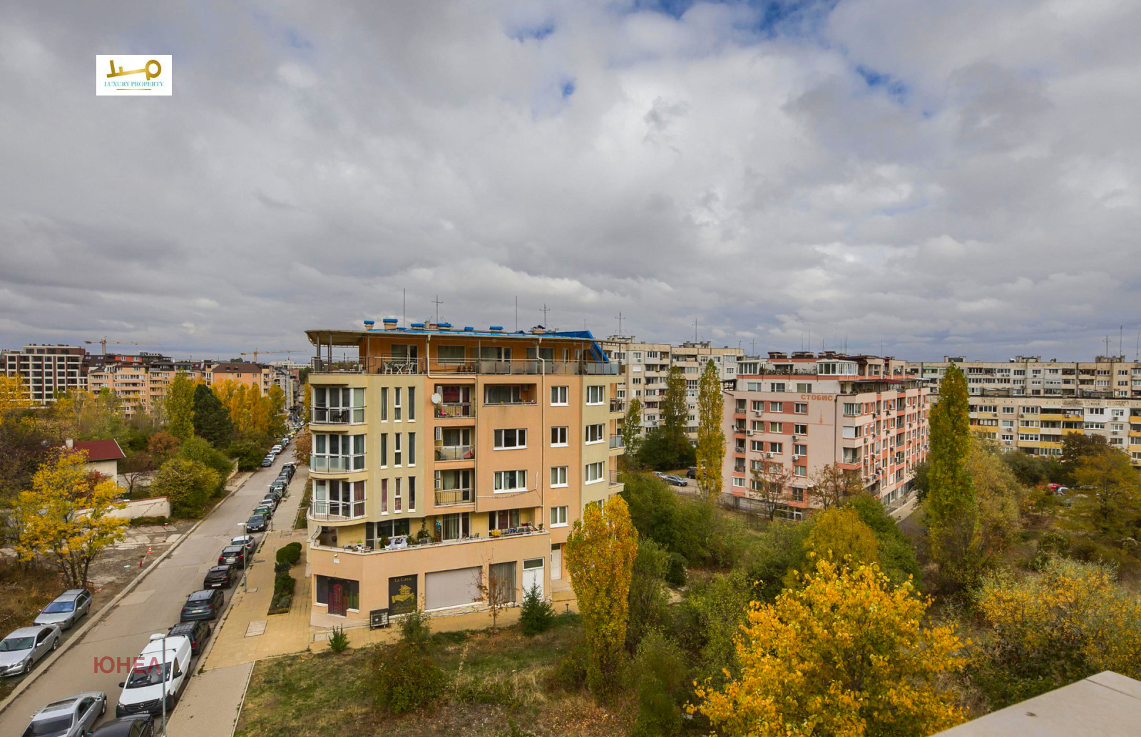 Exterior view of residential buildings surrounded by autumn trees from upper floor