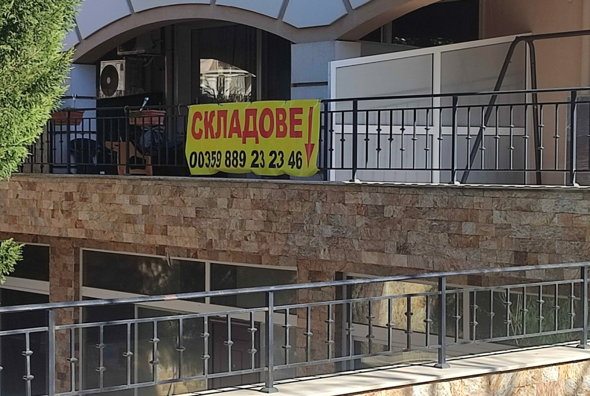 Фасада на сграда с жълт банер за отдаване под наем на складове