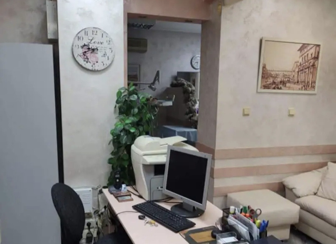 Office area with desk, computer, printer, and decorative wall clock