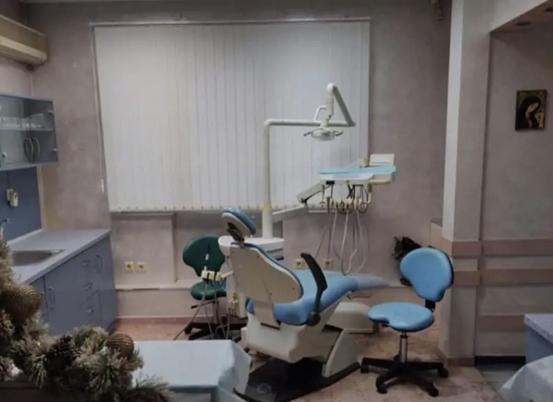 Dental treatment room with blue patient chair and medical equipment