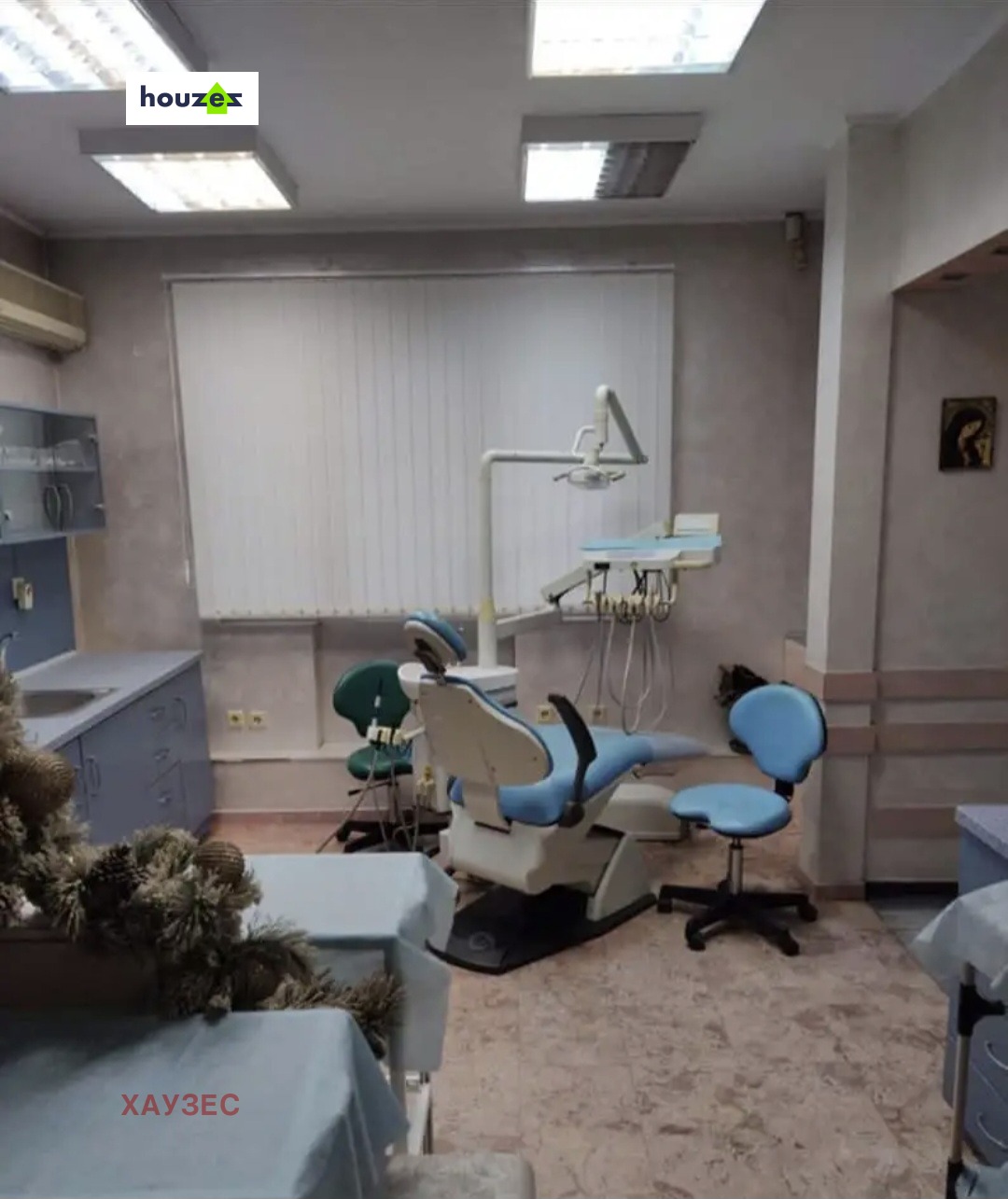 Dental treatment room with blue patient chair and medical equipment